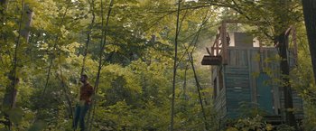 Movie still from “Becky” (2020), directed by Jonathan Milott – A view of trees and a building from the ground; Extreme Wide shot, Low angle