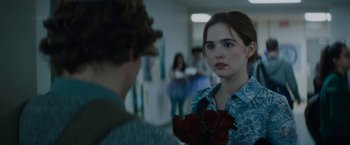 A woman holding a bunch of roses in her hand