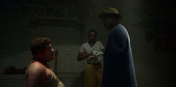 Movie still from “Fargo” (2014), created by Noah Hawley – A group of people standing around in a room; Medium shot, Over the shoulder angle