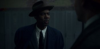 Movie still from “Fargo” (2014), created by Noah Hawley – A man wearing a hat and a suit and tie; Close Up shot, Over the shoulder angle