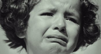 Movie still from “Beginners” (2010), directed by Mike Mills – A young child is crying with tears in his eyes; Extreme Close Up shot, High angle