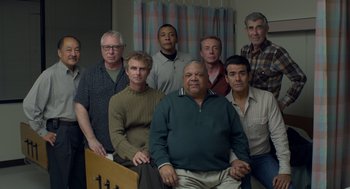 Movie still from “Beginners” (2010), directed by Mike Mills – A group of men standing next to each other in a room; Medium shot, High angle