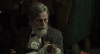 Movie still from “Beginners” (2010), directed by Mike Mills – An old man with a beard holding a white dog; Close Up shot, Over the shoulder angle