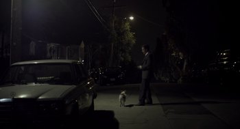 Movie still from “Beginners” (2010), directed by Mike Mills – A man in a suit walking a small white dog; Wide shot, High angle