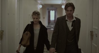 Movie still from “Beginners” (2010), directed by Mike Mills – A man and a woman holding hands while walking down a hall way; Medium shot, Low angle