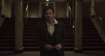Movie still from “Beginners” (2010), directed by Mike Mills – A man standing in front of some stairs; Medium shot, Low angle