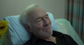 Movie still from “Beginners” (2010), directed by Mike Mills – An older man laying in a hospital bed with his eyes closed; Close Up shot, High angle