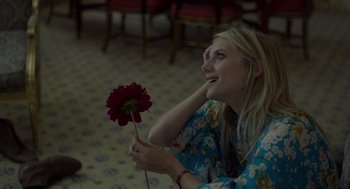 Movie still from “Beginners” (2010), directed by Mike Mills – A beautiful young lady holding a red flower in her hand; Close Up shot, High angle