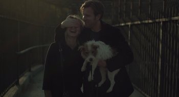 Movie still from “Beginners” (2010), directed by Mike Mills – A man and a woman holding a small white dog; Close Up shot, Over the shoulder angle