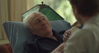 Movie still from “Beginners” (2010), directed by Mike Mills – An older man laying in a chair with a woman; Close Up shot, Over the shoulder angle