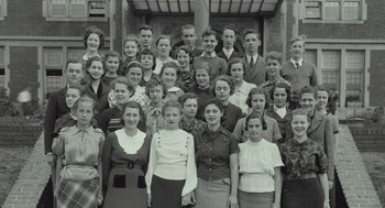 Movie still from “Beginners” (2010), directed by Mike Mills – A group of people standing in front of a brick building; Wide shot, High angle