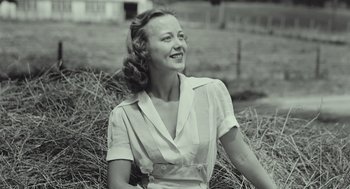 An old photo of a woman sitting in a field