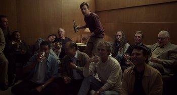 Movie still from “Beginners” (2010), directed by Mike Mills – A group of people sitting around a room drinking wine; Wide shot, High angle