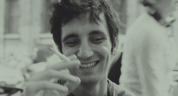 Movie still from “Beginners” (2010), directed by Mike Mills – A person smiling and holding something in his hand; Close Up shot, Low angle