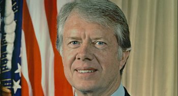 Movie still from “Beginners” (2010), directed by Mike Mills – An older man in a suit with a flag in the background; Close Up shot, Low angle