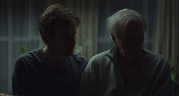 Movie still from “Beginners” (2010), directed by Mike Mills – Two men are looking at each other in a dark room; Close Up shot, Over the shoulder angle
