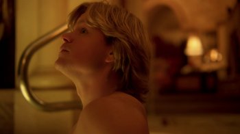 Movie still from “Behind the Candelabra” (2013), directed by Steven Soderbergh – A man with long blonde hair looking upward; Close Up shot, Low angle