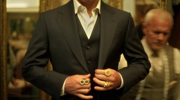 Movie still from “Behind the Candelabra” (2013), directed by Steven Soderbergh – A person wearing a suit and three rings; Medium shot, High angle