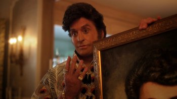 Movie still from “Behind the Candelabra” (2013), directed by Steven Soderbergh – A man holding a painting in front of a mirror; Close Up shot, Over the shoulder angle