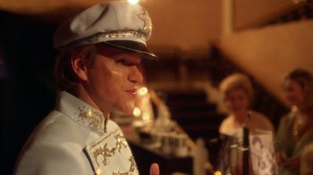 Movie still from “Behind the Candelabra” (2013), directed by Steven Soderbergh – A man wearing a uniform and a hat is smoking a cigarette; Close Up shot, Over the shoulder angle