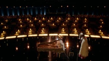Movie still from “Behind the Candelabra” (2013), directed by Steven Soderbergh – A grand piano in front of an audience in a theater; Extreme Wide shot, High angle