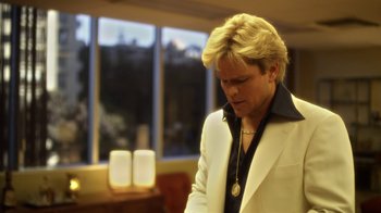 Movie still from “Behind the Candelabra” (2013), directed by Steven Soderbergh – A man in a white jacket looking down at his necklace; Close Up shot, Low angle