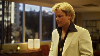 Movie still from “Behind the Candelabra” (2013), directed by Steven Soderbergh – A man with blonde hair wearing a white jacket; Close Up shot, Low angle