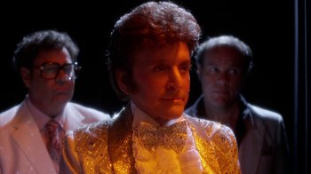 Movie still from “Behind the Candelabra” (2013), directed by Steven Soderbergh – A man in a white suit and bow tie; Close Up shot, Over the shoulder angle