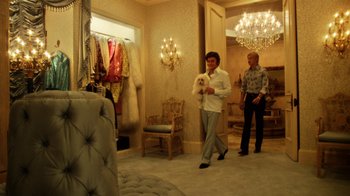 Movie still from “Behind the Candelabra” (2013), directed by Steven Soderbergh – A man and a woman are walking through a room; Wide shot, Over the shoulder angle
