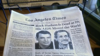 Movie still from “Behind the Candelabra” (2013), directed by Steven Soderbergh – A los angeles times front page with a picture of rock hudson and a picture of his aids victim; Extreme Close Up shot, Overhead angle