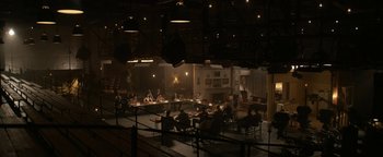 Movie still from “Being the Ricardos” (2021), directed by Aaron Sorkin – A group of people sitting at a table in a dark room; Extreme Wide shot, High angle