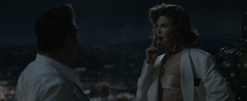 Movie still from “Being the Ricardos” (2021), directed by Aaron Sorkin – A woman in a white dress is talking on a cell phone; Medium shot, Over the shoulder angle