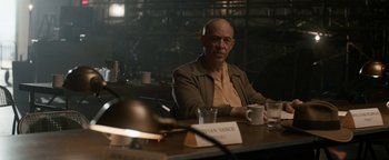 Movie still from “Being the Ricardos” (2021), directed by Aaron Sorkin – A man sitting at a table with a cup of coffee; Medium shot, Over the shoulder angle