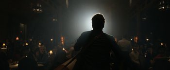 Movie still from “Being the Ricardos” (2021), directed by Aaron Sorkin – A man holding a guitar in a dark room; Medium shot, Low angle