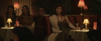 Movie still from “Being the Ricardos” (2021), directed by Aaron Sorkin – A woman sitting on top of a couch next to a man; Medium shot, Over the shoulder angle