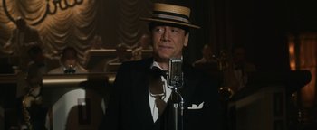 Movie still from “Being the Ricardos” (2021), directed by Aaron Sorkin – A man wearing a straw hat standing in front of a microphone; Close Up shot, Low angle