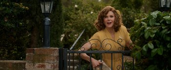 Movie still from “Being the Ricardos” (2021), directed by Aaron Sorkin – A woman in a yellow dress standing in front of an iron gate; Medium shot, Over the shoulder angle