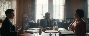 Movie still from “Being the Ricardos” (2021), directed by Aaron Sorkin – A man sitting at a table reading a book; Medium shot, Over the shoulder angle