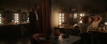 Movie still from “Being the Ricardos” (2021), directed by Aaron Sorkin – A man standing in front of a table with a bowl of fruit on top of it; Wide shot, Over the shoulder angle