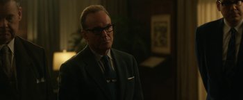 Movie still from “Being the Ricardos” (2021), directed by Aaron Sorkin – A man in a suit and tie standing in front of a desk; Close Up shot, Over the shoulder angle