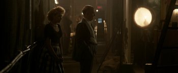 Movie still from “Being the Ricardos” (2021), directed by Aaron Sorkin – A man and a woman standing next to each other in a dark room; Medium shot, Over the shoulder angle