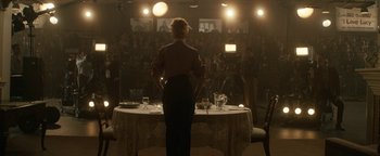 Movie still from “Being the Ricardos” (2021), directed by Aaron Sorkin – A woman standing in front of a dinner table; Wide shot, Over the shoulder angle
