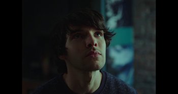 A man with long dark hair is looking up