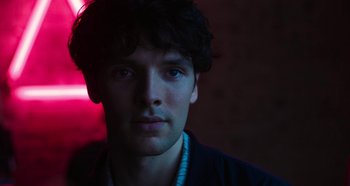 A young man with blue eyes stares at the camera
