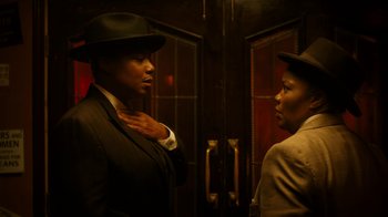 Movie still from “Bessie” (2015), directed by Dee Rees – Two men in suits are standing in front of a door; Medium shot, Low angle