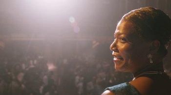 Movie still from “Bessie” (2015), directed by Dee Rees – A person smiling in a crowd of people; Close Up shot, Low angle