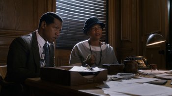 Movie still from “Bessie” (2015), directed by Dee Rees – A couple of people sitting at a wooden table; Medium shot, Over the shoulder angle