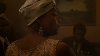 Movie still from “Bessie” (2015), directed by Dee Rees – A person wearing a dress and a hat; Medium shot, Over the shoulder angle
