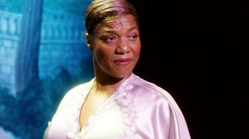 Movie still from “Bessie” (2015), directed by Dee Rees – An older woman in a pink dress is posing for a picture; Close Up shot, Low angle