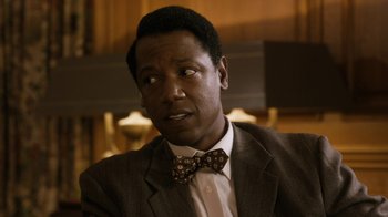 Movie still from “Bessie” (2015), directed by Dee Rees – A person wearing a suit and a bow tie; Close Up shot, Over the shoulder angle